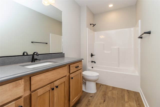 full bathroom with wood-type flooring, washtub / shower combination, vanity, and toilet