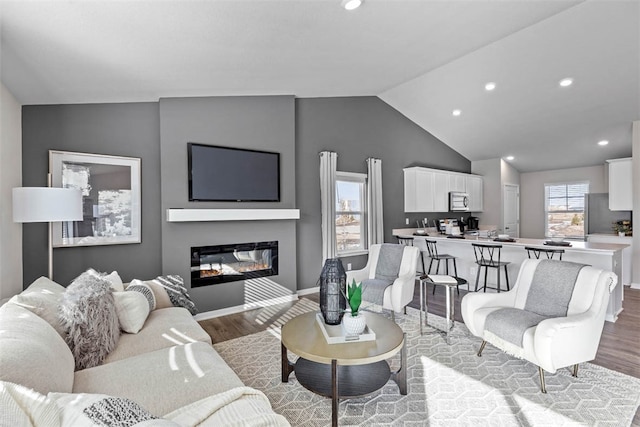 living room with vaulted ceiling and light hardwood / wood-style floors