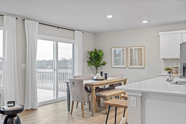 dining room with sink and light wood-type flooring