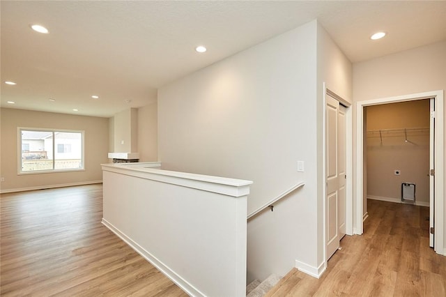 hallway with heating unit and light hardwood / wood-style floors