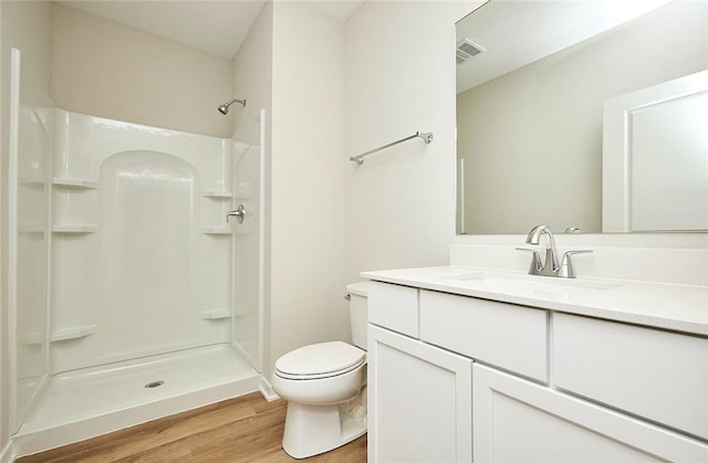 bathroom featuring vanity, toilet, wood-type flooring, and walk in shower