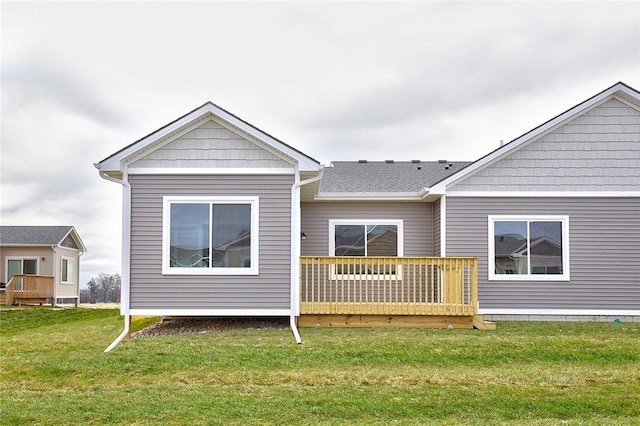 back of property with a deck and a lawn