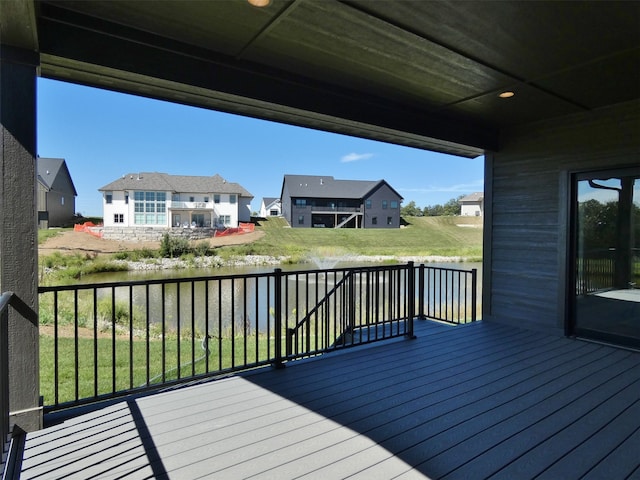 wooden deck featuring a water view and a yard