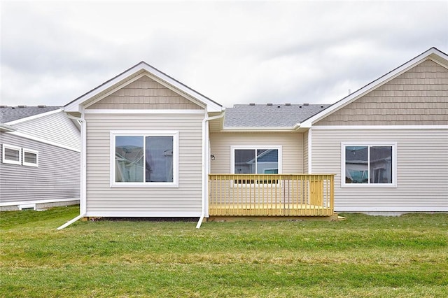 rear view of house featuring a lawn and a wooden deck