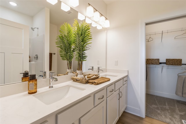 bathroom with vanity, hardwood / wood-style flooring, and a shower