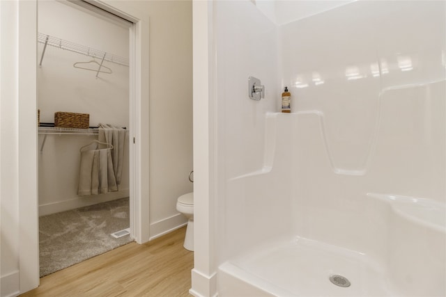 bathroom featuring toilet, hardwood / wood-style flooring, and a shower