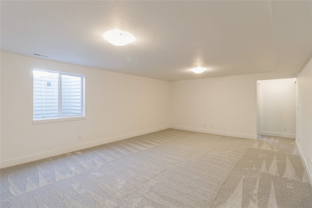 carpeted empty room featuring a textured ceiling