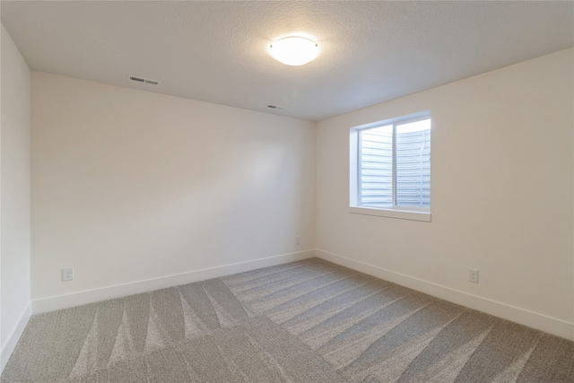 carpeted spare room featuring a textured ceiling