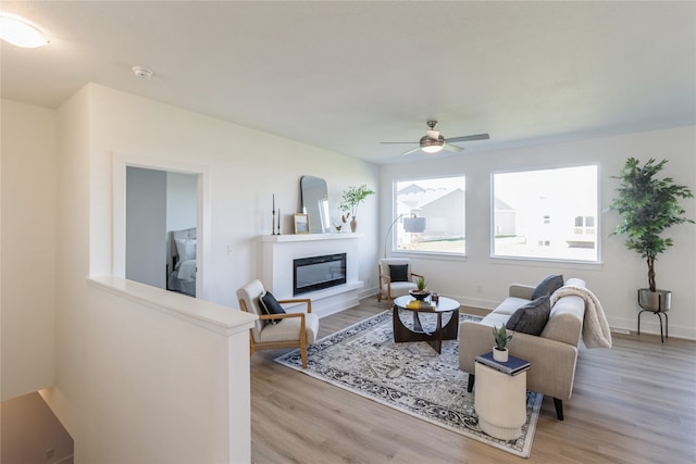 living room featuring light hardwood / wood-style flooring and ceiling fan