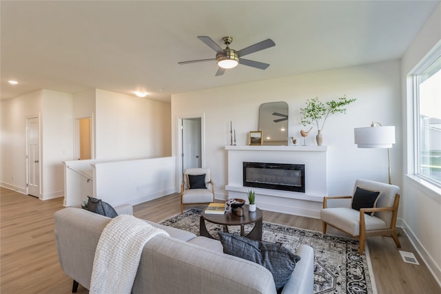 living room with ceiling fan and light wood-type flooring