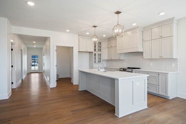 2814 NW Westwood Ct, Ankeny, IA 50023 - kitchen with tasteful backsplash, a center island with sink, range, and dark hardwood / wood-style flooring