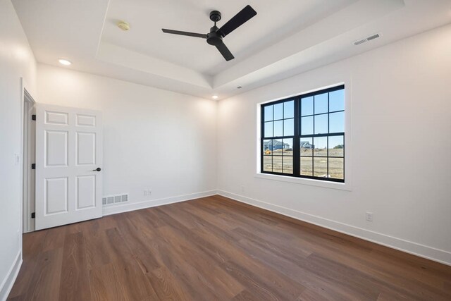 2814 NW Westwood Ct, Ankeny, IA 50023 - unfurnished room featuring a tray ceiling, ceiling fan, and dark hardwood / wood-style flooring