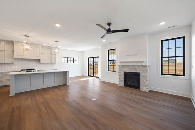 2814 NW Westwood Ct, Ankeny, IA 50023 - kitchen with decorative light fixtures, ceiling fan with notable chandelier, dark hardwood / wood-style flooring, and an island with sink