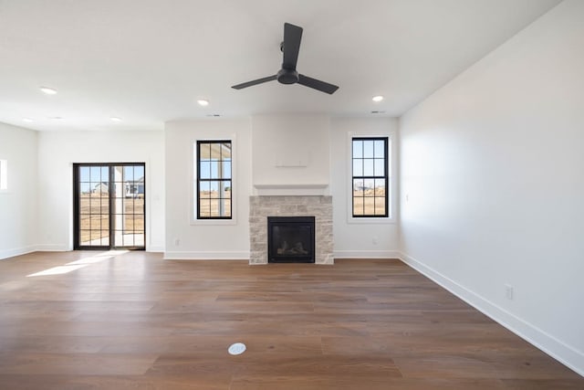 2814 NW Westwood Ct, Ankeny, IA 50023 - unfurnished living room featuring dark hardwood / wood-style flooring, ceiling fan, and a stone fireplace
