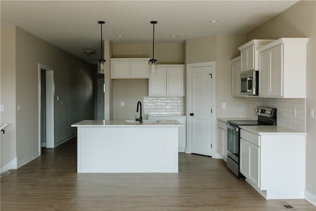 kitchen with decorative light fixtures, appliances with stainless steel finishes, and white cabinetry