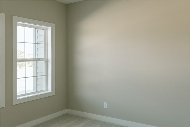 carpeted spare room featuring a healthy amount of sunlight