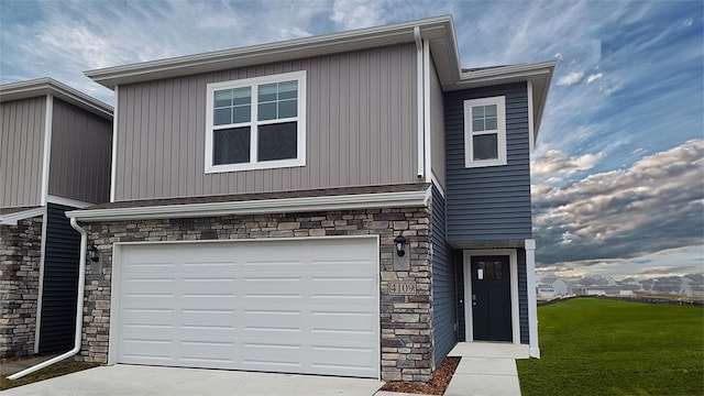 2211 Bugge Dr, Adel, IA 50003 - view of front facade featuring stone siding, an attached garage, concrete driveway, and a front lawn