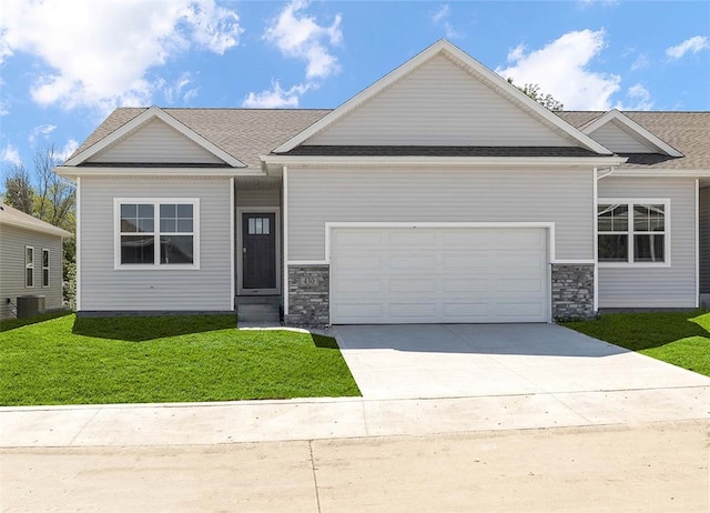 craftsman house featuring central AC unit, a front yard, and a garage