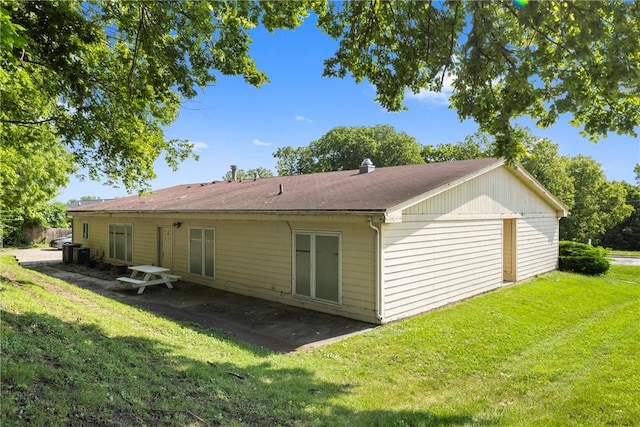 back of property featuring central AC unit, a patio, and a lawn