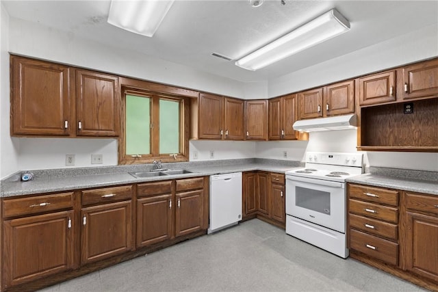 kitchen with white appliances, light floors, under cabinet range hood, a sink, and brown cabinets