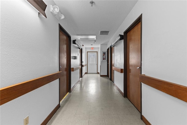 hall with visible vents and baseboards