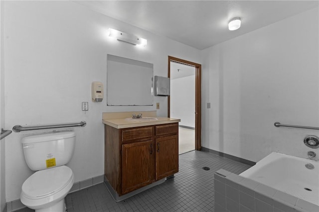 bathroom with vanity, baseboards, tile patterned flooring, toilet, and tiled tub