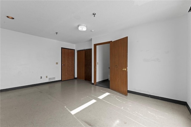 unfurnished room with visible vents and baseboards