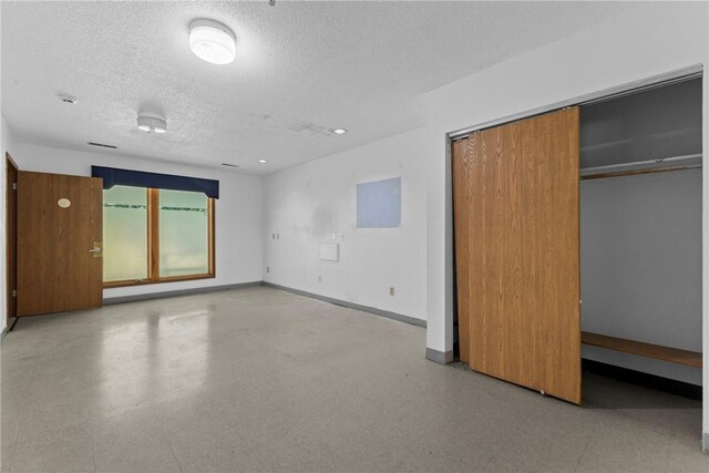 interior space featuring a closet, tile patterned floors, baseboards, and a textured ceiling