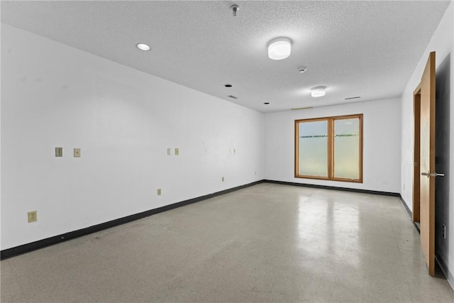 empty room with baseboards and a textured ceiling