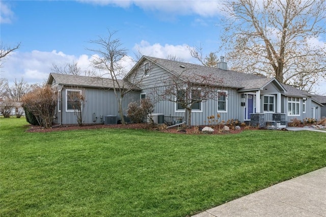 exterior space featuring central AC unit and a front lawn