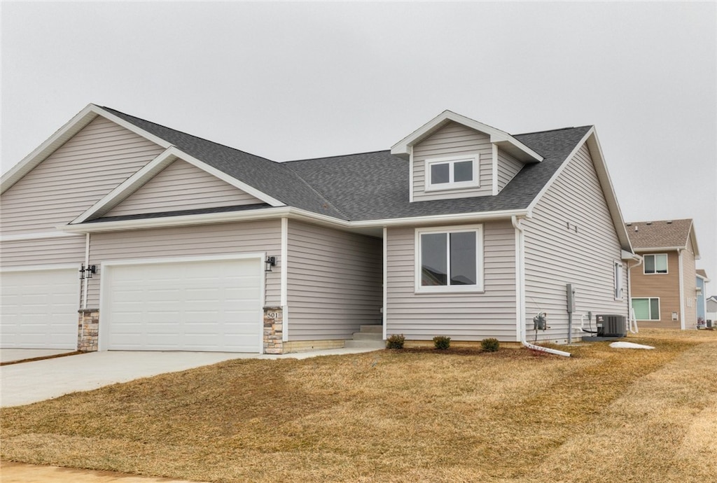 view of front facade with central air condition unit, a front lawn, and a garage