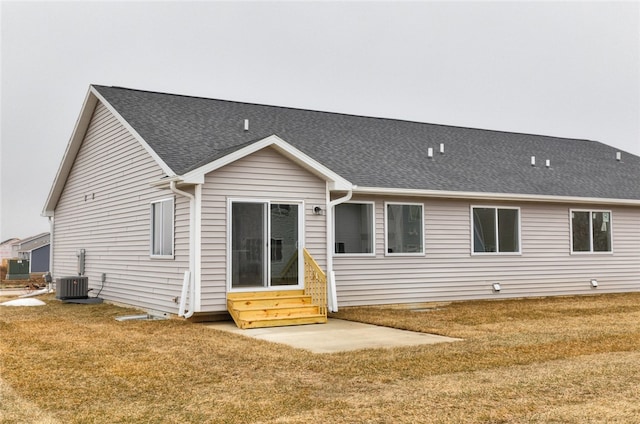 back of property featuring central AC unit and a yard