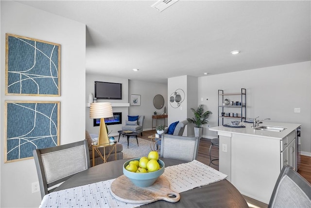 dining space with wood-type flooring, sink, and wine cooler