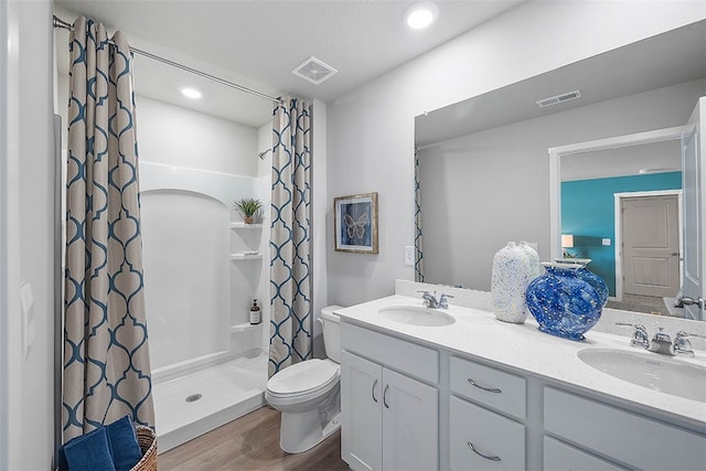 bathroom featuring vanity, hardwood / wood-style flooring, toilet, and curtained shower