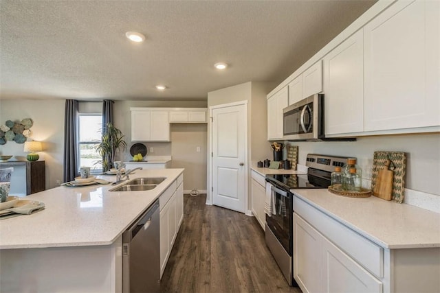 kitchen with sink, white cabinets, a textured ceiling, dark hardwood / wood-style floors, and appliances with stainless steel finishes