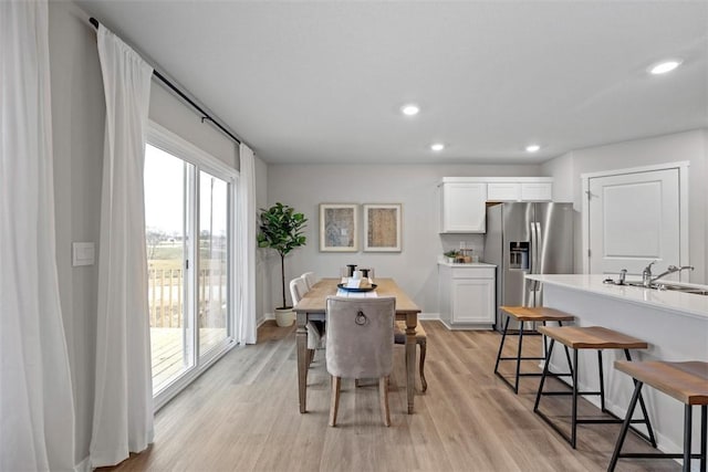 dining space featuring light wood-type flooring and sink