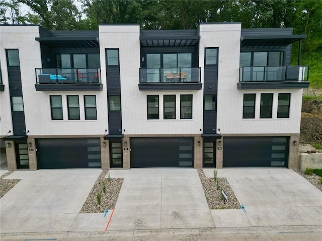 view of front of home with brick siding, driveway, and an attached garage