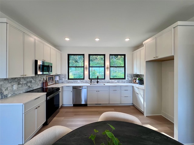 kitchen with a sink, decorative backsplash, plenty of natural light, and stainless steel appliances