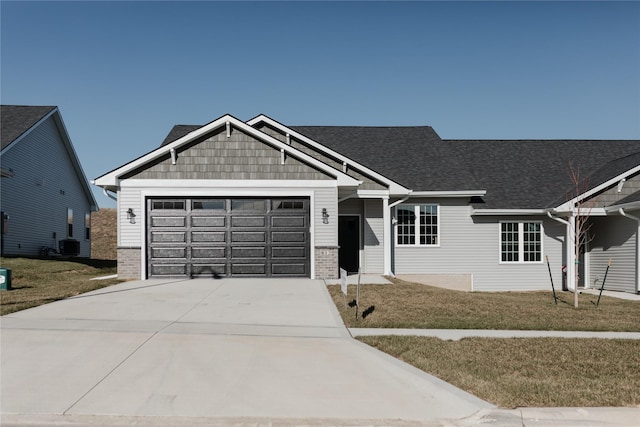 view of front of property with a front yard, a garage, and cooling unit