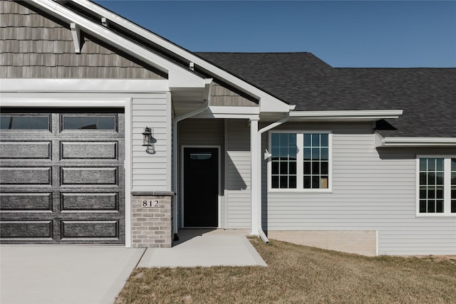 doorway to property featuring a lawn and a garage