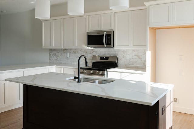 kitchen featuring white cabinetry, stainless steel appliances, and a kitchen island with sink