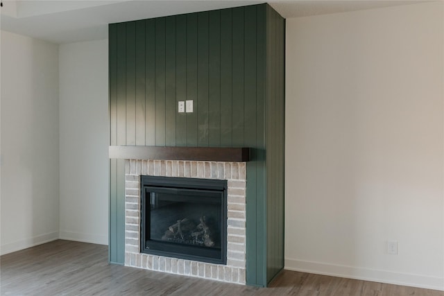 details featuring wood walls, a fireplace, and hardwood / wood-style floors