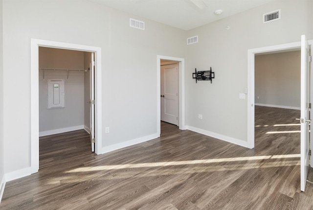 unfurnished bedroom with a walk in closet, dark hardwood / wood-style floors, and a closet