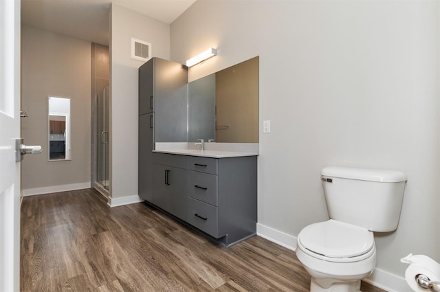 bathroom featuring hardwood / wood-style flooring, vanity, toilet, and an enclosed shower