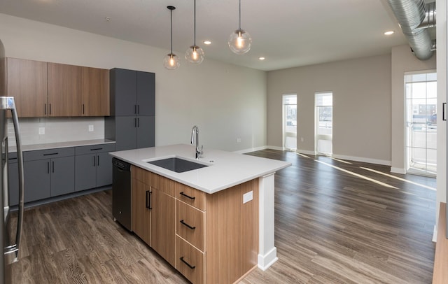 kitchen featuring dark wood-type flooring, sink, dishwasher, hanging light fixtures, and an island with sink