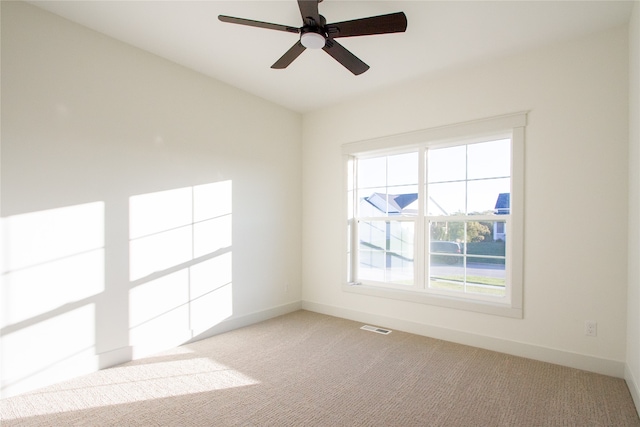 empty room featuring ceiling fan and light carpet