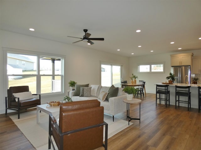 living room with ceiling fan, a healthy amount of sunlight, and dark hardwood / wood-style floors