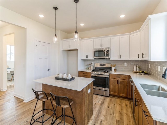 kitchen featuring white cabinetry, a center island, stainless steel appliances, and sink