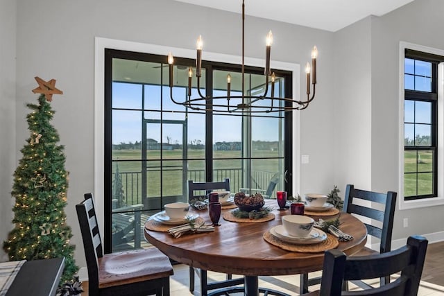 dining area with a wealth of natural light, a chandelier, and hardwood / wood-style flooring