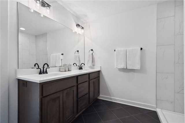 bathroom with tile patterned flooring, vanity, and a textured ceiling